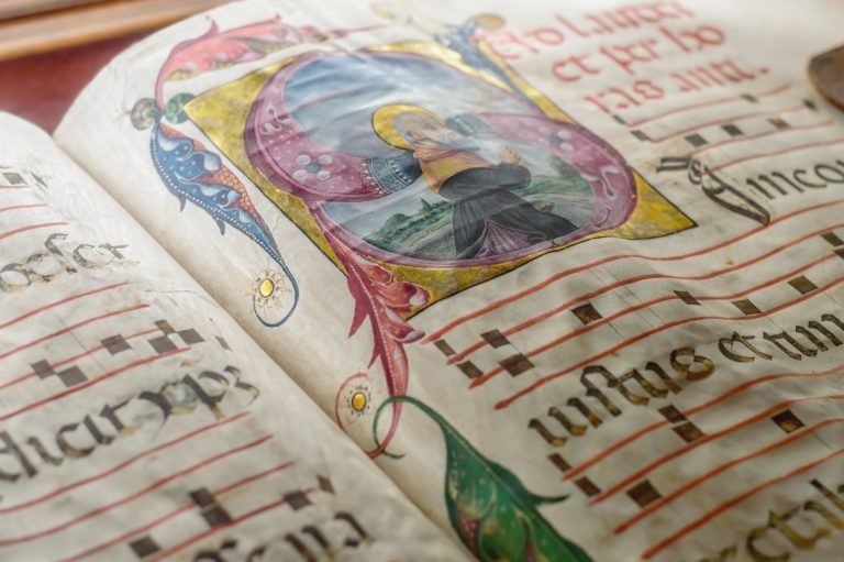 Genova, Italy - July 2015 - Medieval ancient illustrated illuminated monastic manuscript with sheet music Gregorian chant, illustrative editorial, artistic selective focus